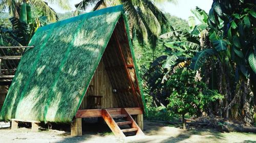 a small hut with a green roof and a ladder at Camp Irog Daraitan in Damasanan