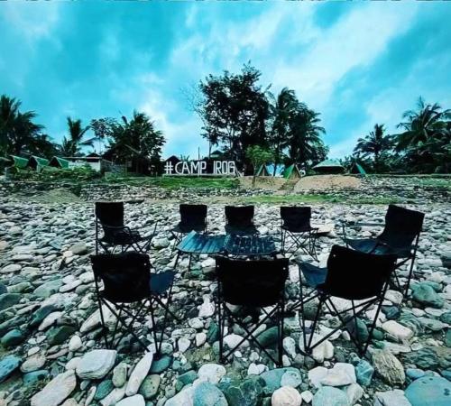 a group of chairs and a table on a rocky beach at Camp Irog Daraitan in Damasanan