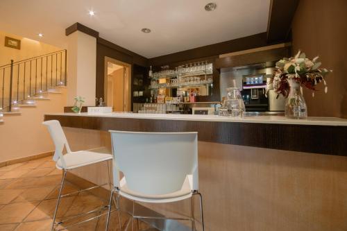 a bar with two white chairs and a counter at Green Hotel Poggio Regillo in Frascati