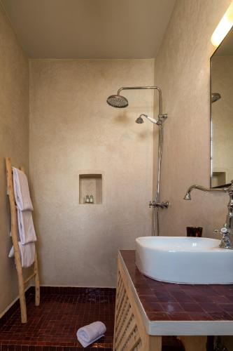 a bathroom with a sink and a mirror and a tub at Dar Babette in Marrakesh