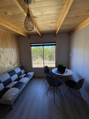 a room with a couch and a table with chairs at Cabañas Aurora in Quilquico
