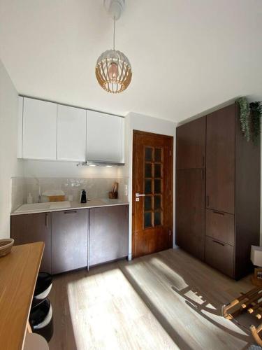 une cuisine avec des armoires blanches et un plancher en bois dans l'établissement Sublime studio avec terrasse, à La Colmiane