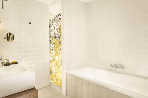 une salle de bain blanche avec une baignoire et un lavabo dans l'établissement Panorama viewz, à Toulouse