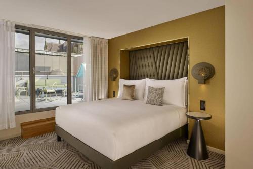 une chambre avec un grand lit et une grande fenêtre dans l'établissement Panorama viewz, à Toulouse