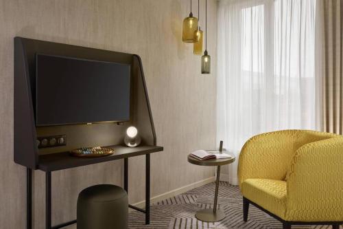 un salon avec une télévision et une chaise dans l'établissement Panorama viewz, à Toulouse