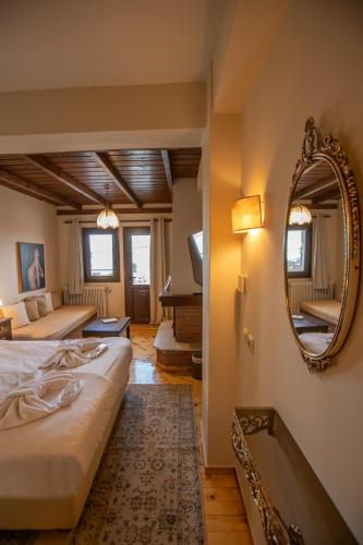 a bedroom with two beds and a mirror and a piano at Archontiko Zakoni in Neochori
