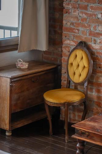 a chair sitting next to a wooden desk with a dresser at Archontiko Zakoni in Neochori