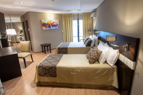 プエルトイグアスにあるBagu ÑAMANDU GUAZUのベッド2台とリビングルームがあるホテルの部屋