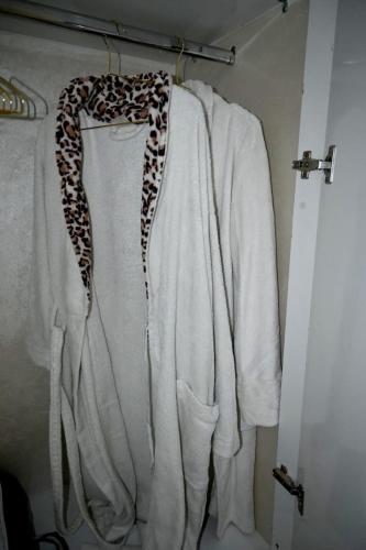 a white sweater with a leopard scarf hanging on a closet at Hogar Feliz - apartment in Agadir