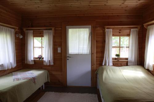 KalmariにあるTähdikki Cottageのログキャビン内のベッドルーム1室(ベッド2台付)