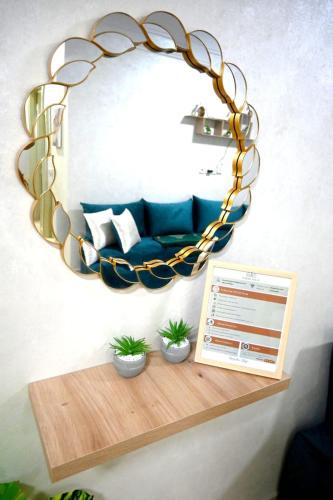 a circular mirror on a wall with a blue couch at Hogar Feliz - apartment in Agadir