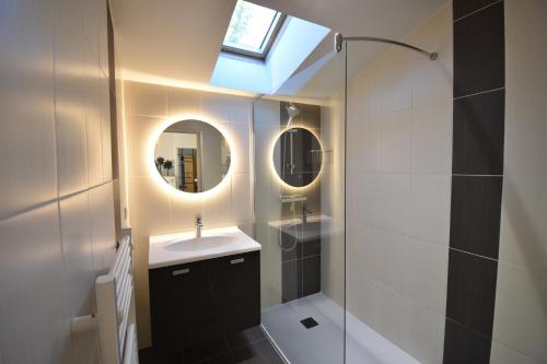 une salle de bain avec un lavabo, un miroir et une douche dans l'établissement Lou Mae - Capbreton - Magnifique Villa à 800 m de l'Océan et à proximité du port de plaisance, à Capbreton