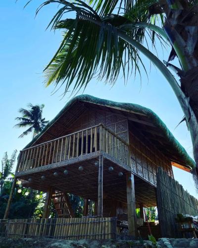 a large wooden hut with a palm tree at Camp Irog Daraitan in Damasanan