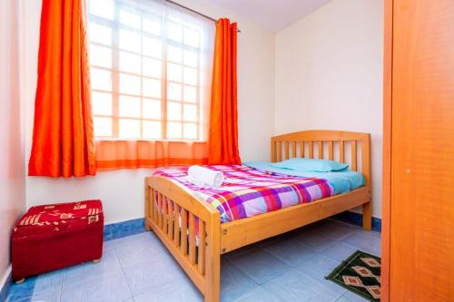 a small bedroom with a bed and a window at Adriel Stay in Nairobi