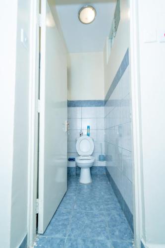 a bathroom with a white toilet in a room at Adriel Stay in Nairobi