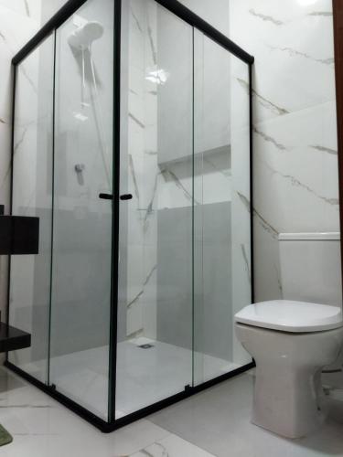 a glass shower in a bathroom with a toilet at Casa Amarte - Sobrado Privado com Garagem in Guaíra