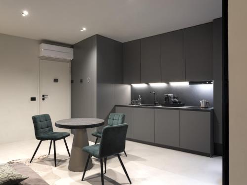 a kitchen with black cabinets and a table and chairs at Officine Cavour CASA DEI LEONI Centro Storico Padova in Padova