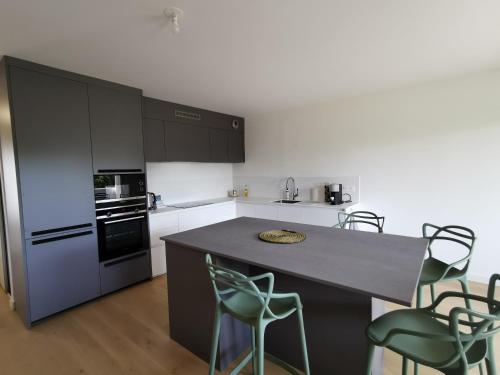 - une cuisine avec un comptoir et des chaises dans l'établissement Olympe, à La Rochelle