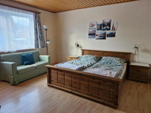 sypialnia z łóżkiem, kanapą i oknem w obiekcie Ferienwohnung Hohengaßner w mieście Mariapfarr