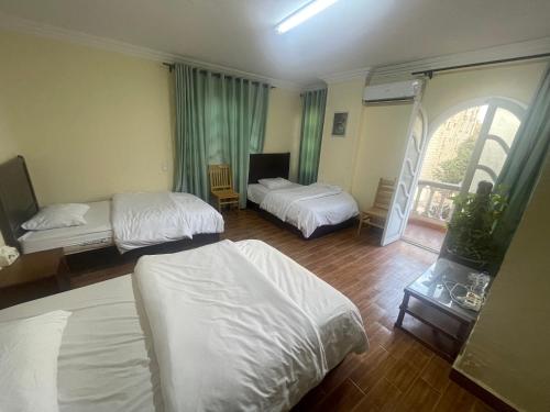 a hotel room with two beds and a window at Xibei Lou Hotel 西北楼华人宾馆 in Cairo