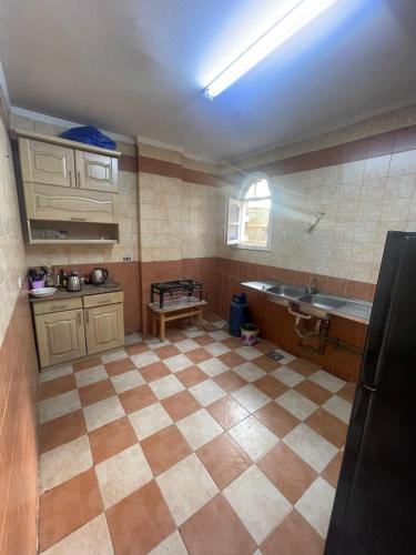 a kitchen with a sink and a tiled floor at Xibei Lou Hotel 西北楼华人宾馆 in Cairo