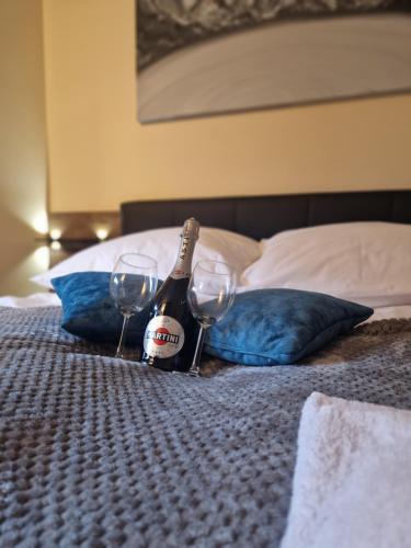 a bottle of champagne and two glasses on a bed at Apartament Spokojny Czas in Wisła