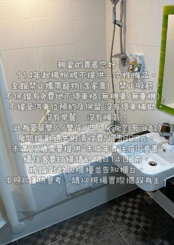 a bathroom with a sink and a shower curtain at Young Soarlan Hotel - Tainan in Tainan