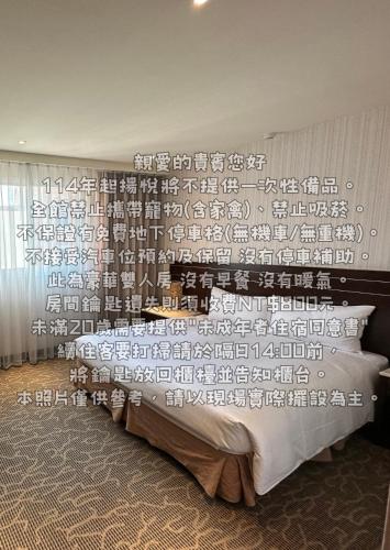 a bedroom with a large bed with a wall with writing at Young Soarlan Hotel - Tainan in Tainan