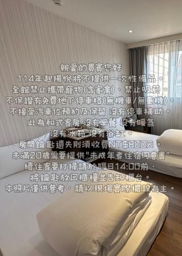 a bedroom with two beds and a wall with writing on it at Young Soarlan Hotel - Tainan in Tainan