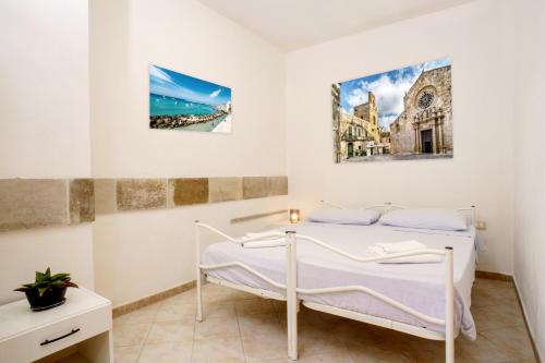 a bedroom with a bed and a painting on the wall at Residence Atenaion in Otranto