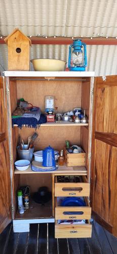 a kitchen with wooden shelves and utensils at Dopper Joris Bruidswa Adam se Uitspanning in Orania