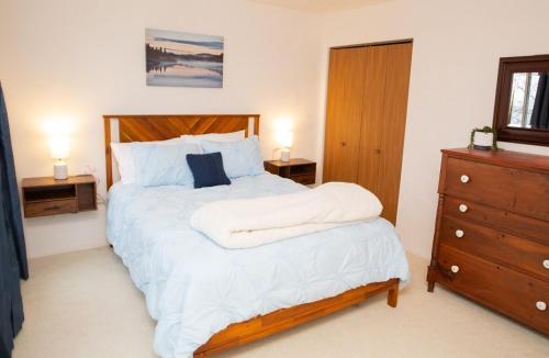 a bedroom with a bed with white sheets and a dresser at Eagles Mountain Retreat in Somerset