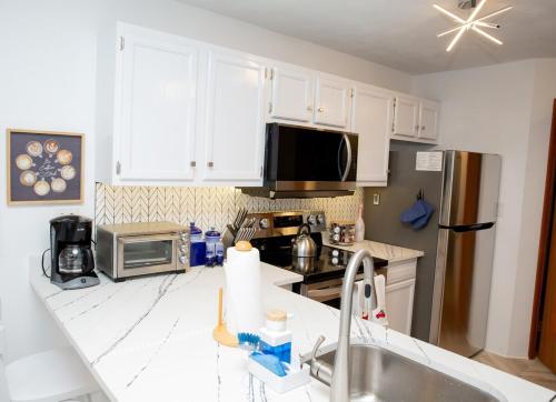 a kitchen with white cabinets and a stainless steel refrigerator at Eagles Mountain Retreat in Somerset