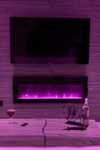 a living room with a fireplace with purple lights at L'OLYMPE DES SENS in Portiragnes