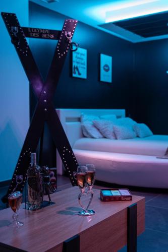 a room with a table with wine glasses and a bed at L'OLYMPE DES SENS in Portiragnes