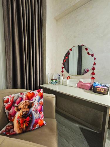 a room with a table and a chair with a pillow at Double View Apartment Mamaia in Mamaia