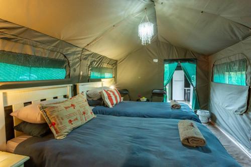 a bedroom with two beds in a tent at Die Fonteine Country Guesthouse and Glamping in Oudtshoorn