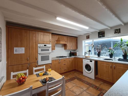 eine Küche mit Holzschränken und einem Tisch mit Obst darauf in der Unterkunft Geneva Cottage - close to Darlington train station in Darlington