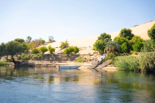 a boat sitting on the side of a river at Anoosh camp in Aswan