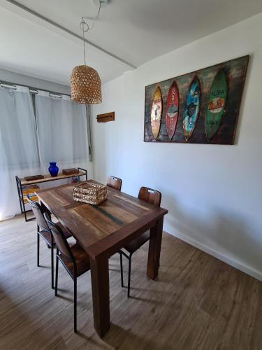 une salle à manger avec une table en bois et des planches de surf murales dans l'établissement Charmant appartement à 50 m de la plage, à Palavas-les-Flots