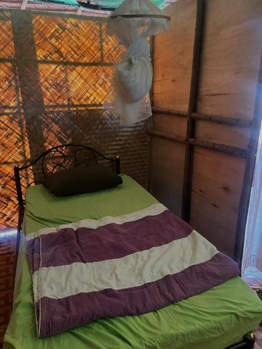 a bed in a room with a wall at Hula Hula Sunset, Dome in Pai