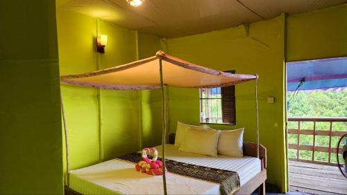 a bedroom with a bed in a green room at Sea Views bungalow kohrong in Koh Rong Island