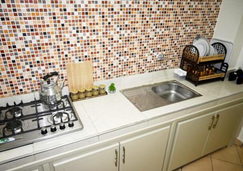 a kitchen counter with a sink and a stove at Hogar Feliz - apartment in Agadir