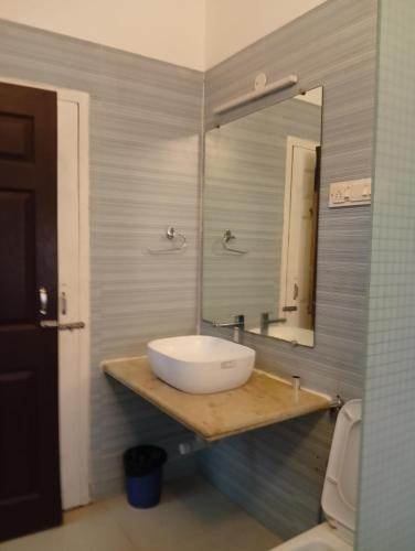 a bathroom with a white sink and a mirror at Jass luxury stays in Anjuna
