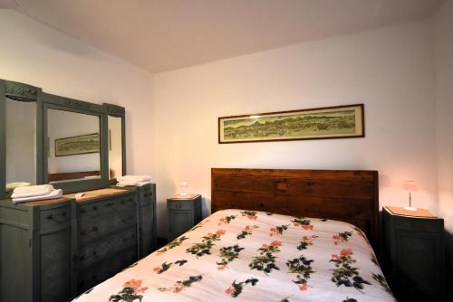 a bedroom with a bed and a dresser and a mirror at Villa Panorama Exclusive Pool in Loro Ciuffenna