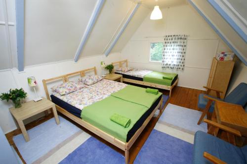 Schlafzimmer im Dachgeschoss mit 2 Betten und einem Stuhl in der Unterkunft Harangvirág 36 Faház in Kismaros