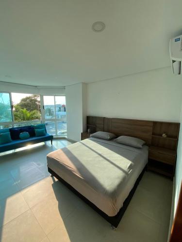 a bedroom with a large bed and a couch at Laguito Apartment in Cartagena de Indias