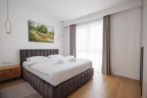 a bedroom with a large bed and a large window at Moldovei 2 Apartments by Central Park in Cluj-Napoca