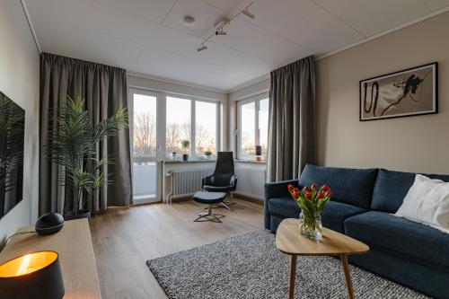 a living room with a blue couch and a table at Förstklassig bekvämlighet! in Jönköping