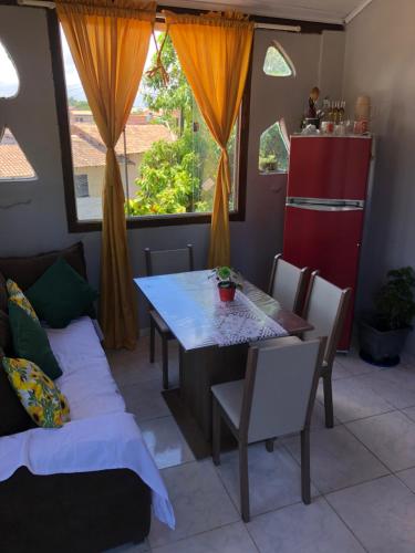 una sala da pranzo con un tavolo e un divano di Casa Privativa em Arraial d'Ajuda - 1 Quarto com 2 camas, Cozinha e Banheiro - 10 Minutos do Centro a Arraial d'Ajuda